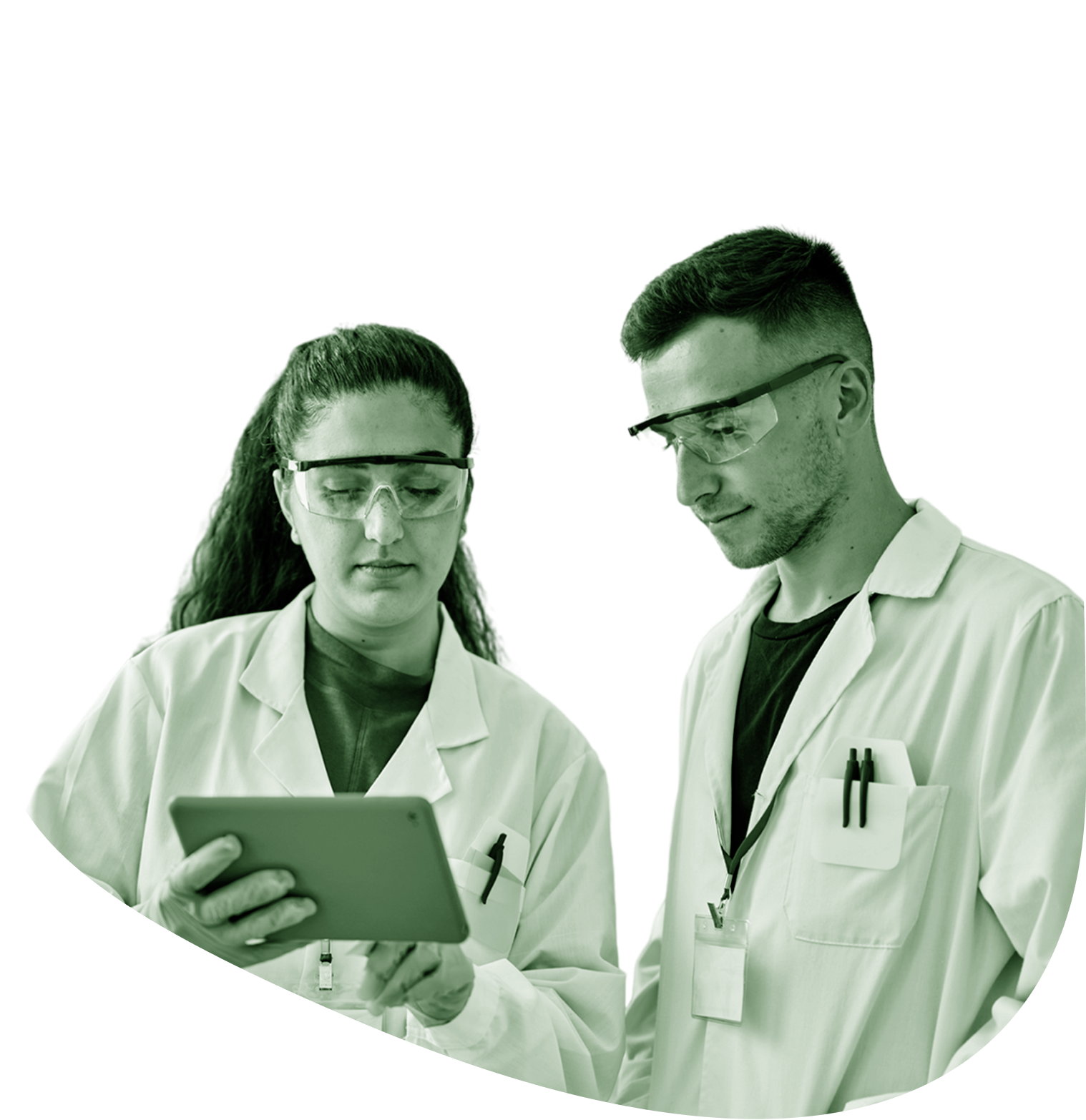 Two women in lab coats and protective eyewear look through a miscroscope